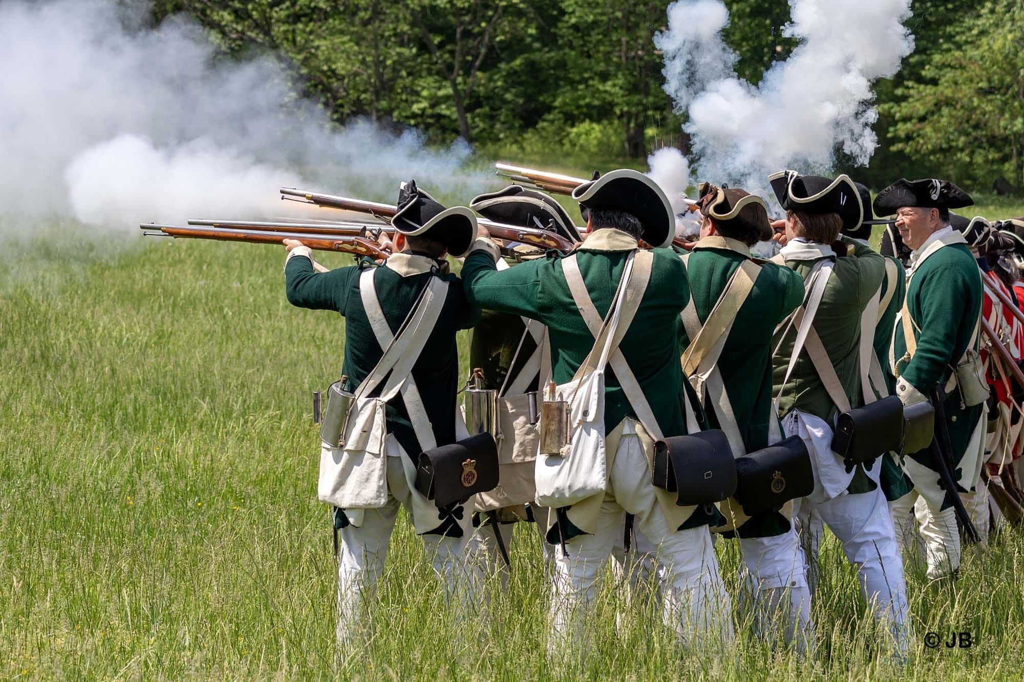 Revolutionary War soldiers firing muskets.